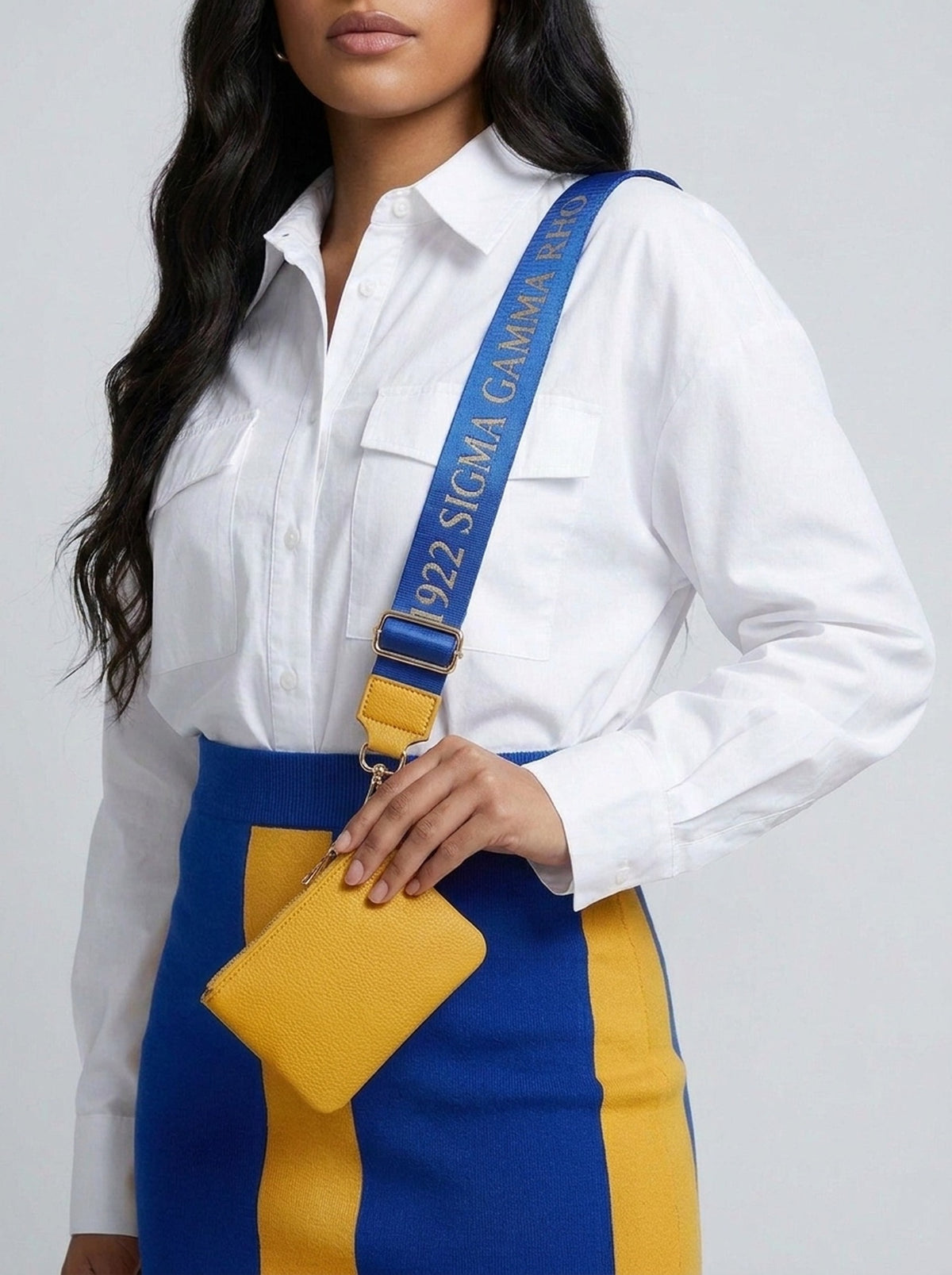 Sigma Gamma Rho purse strap worn crossbody over a white shirt, gold coin wallet in hand